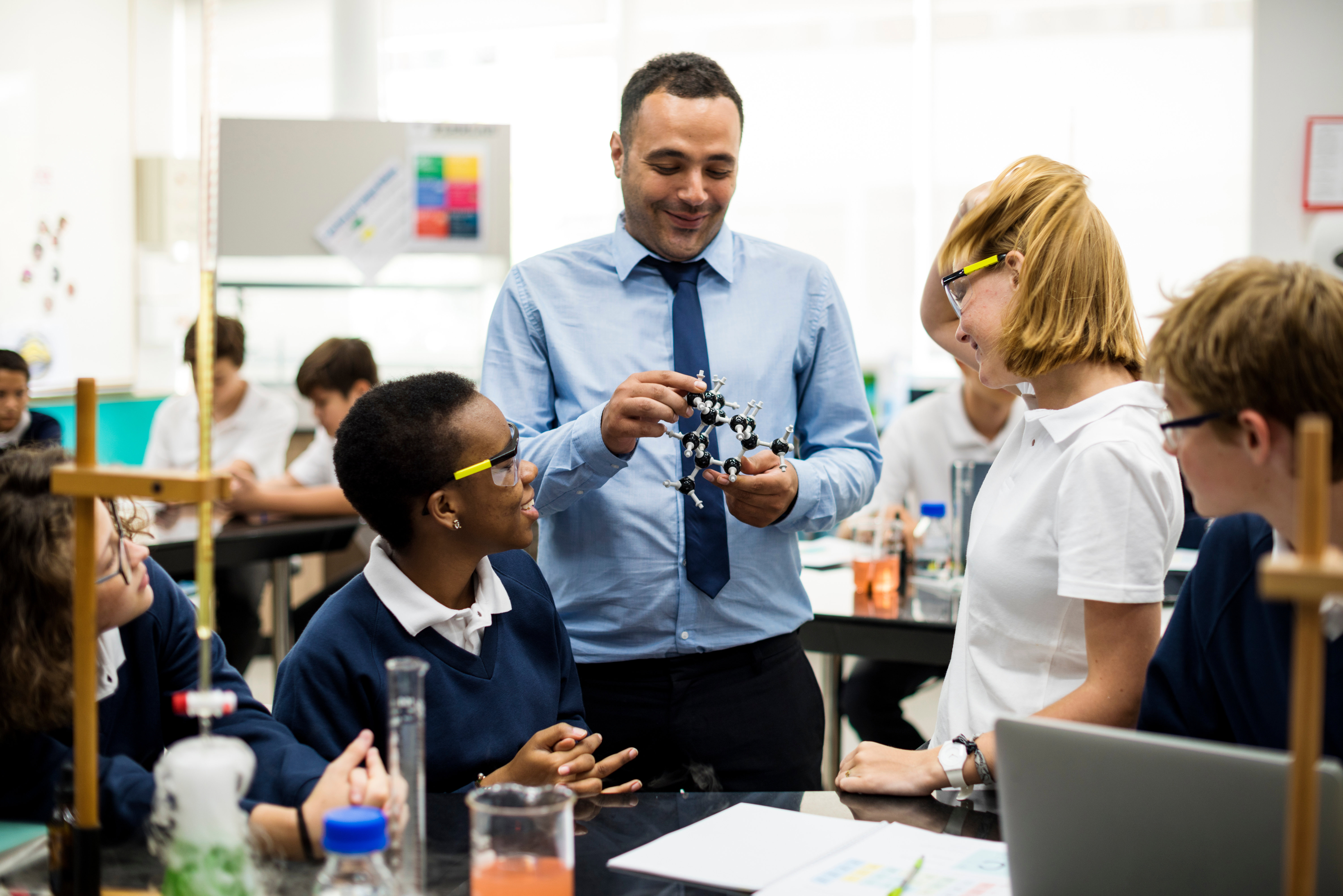 A teacher shows a chemical model to his students